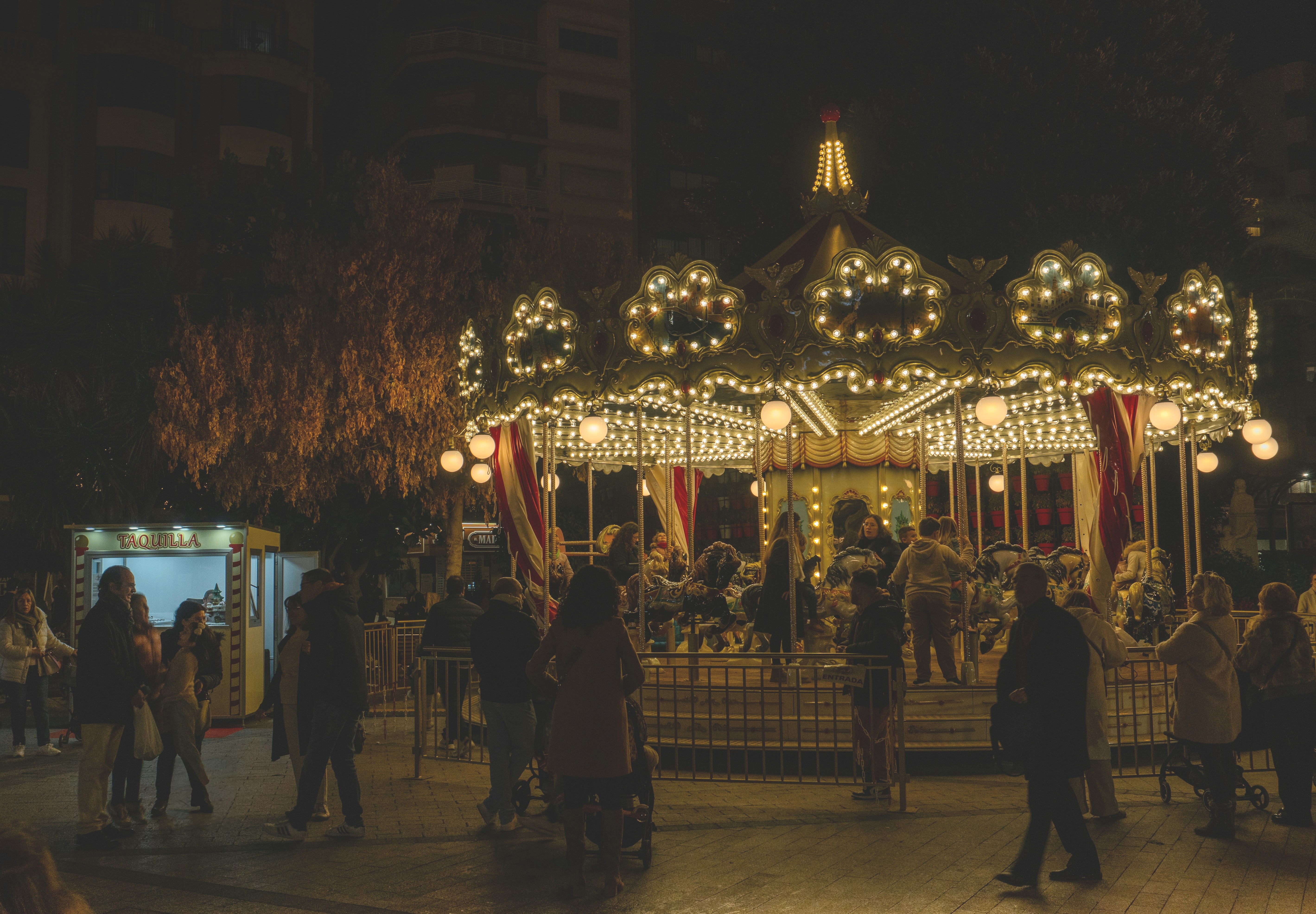 Night-time fairground carousel at Plaza Santo Domingo in Murcia, showing the city&rsquo;s seasonal fairground atmosphere.