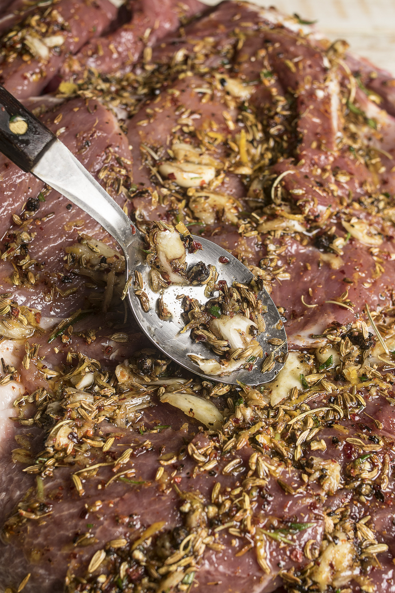 Fennel seed, garlic, rosemary and lemon seasoning spread over pork for homemade porchetta