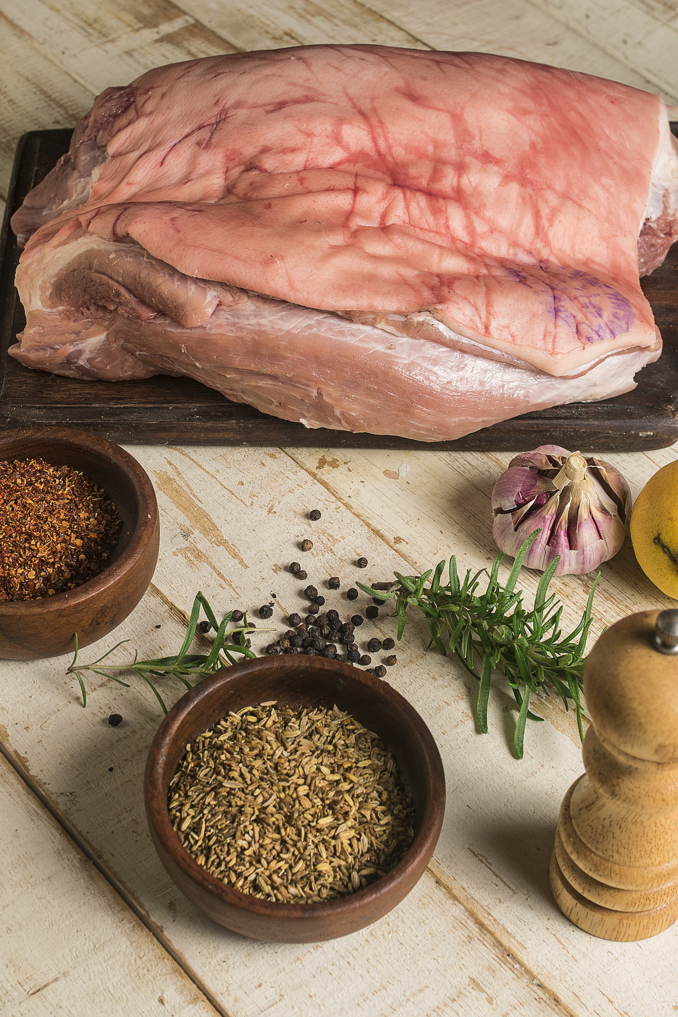 Raw pork with fennel seeds, rosemary, garlic, black pepper and lemon ready for homemade porchetta