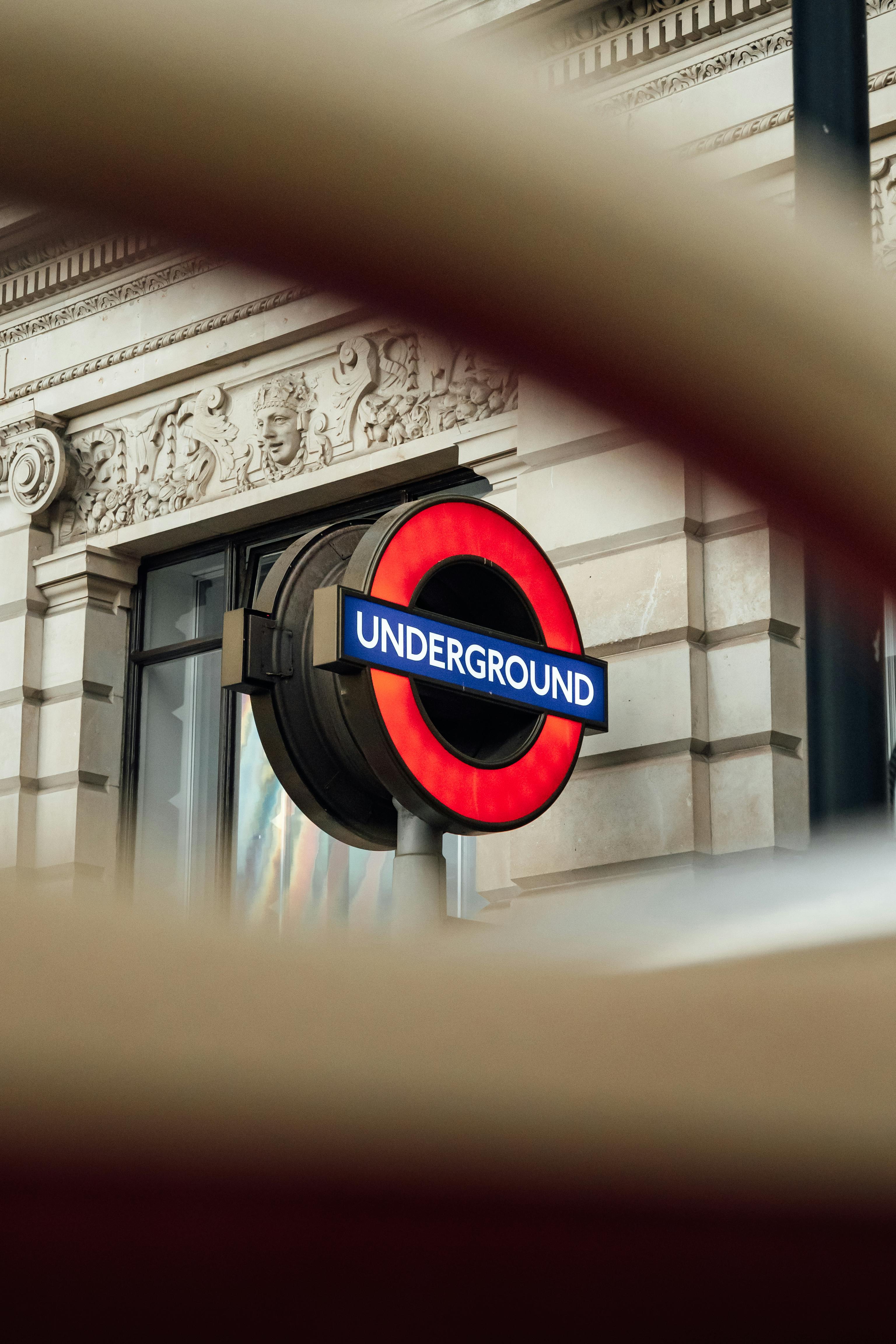 London Underground sign seen through architectural framing, useful for visitors planning public transport routes across London.