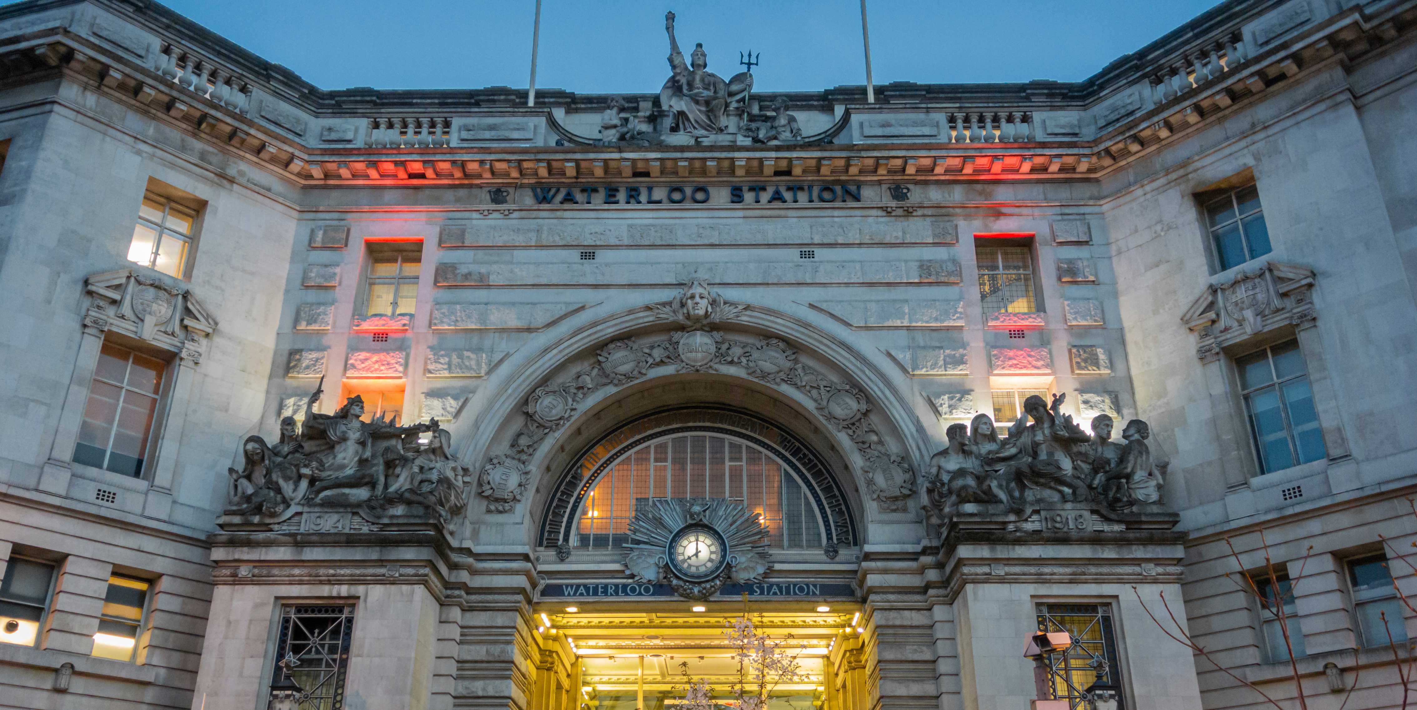 Exterior of London Waterloo Station at dusk, a major rail hub for journeys towards Wimbledon and southwest London.